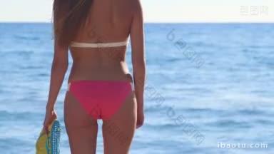 夏天海滩上，穿着粉色比基尼和人字拖的女孩